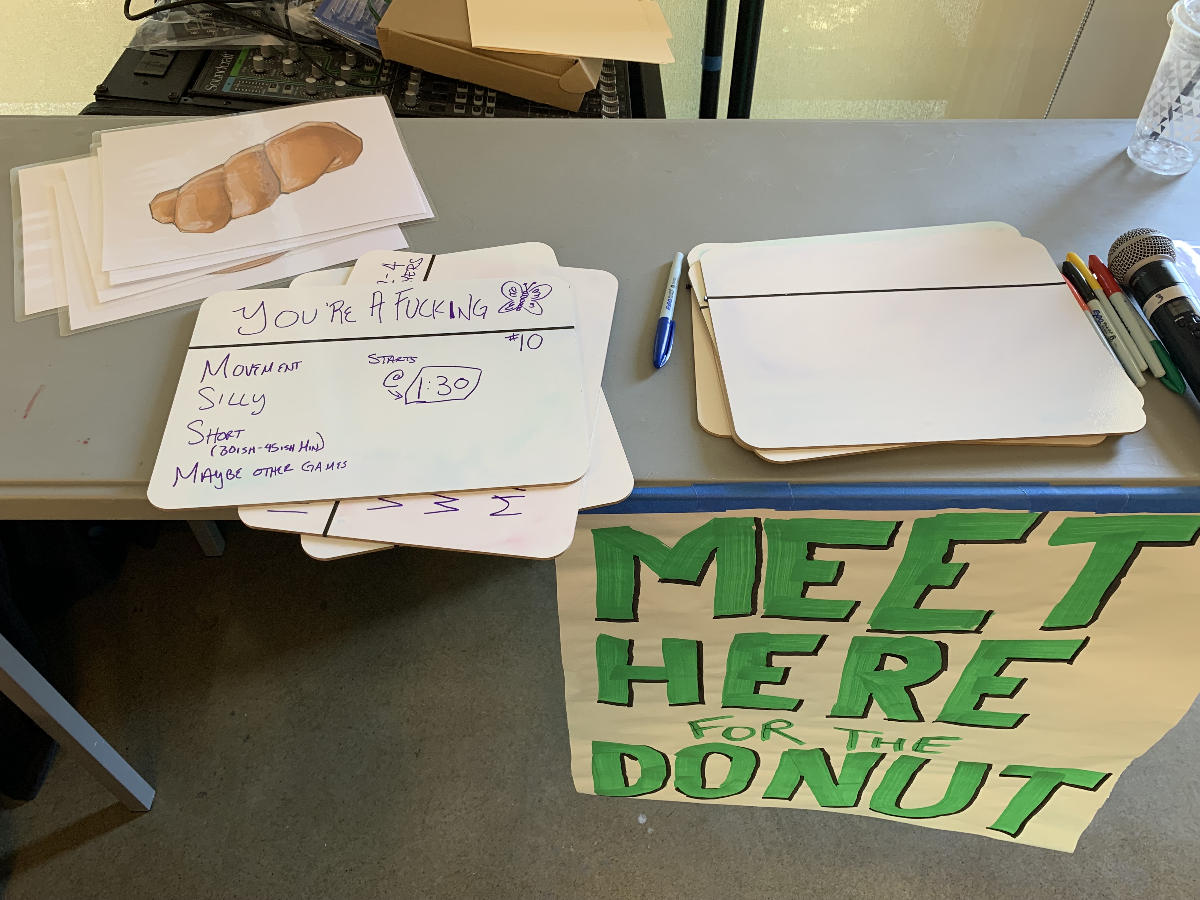 Photograph of the Donut sign-up table with a sign saying "Meet here for the Donut" and an example of a game pitch.