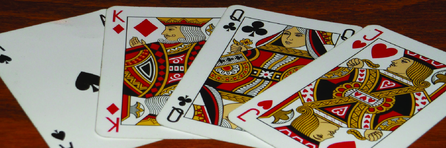 Four poker-sized playing cards fanned out on a table.